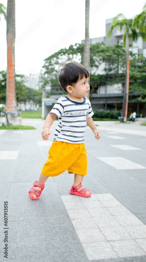 A Malay boy wearing stripes clothes and yellow pants at the bay A Malay boy wearing stripes clothes and yellow pants at the bay