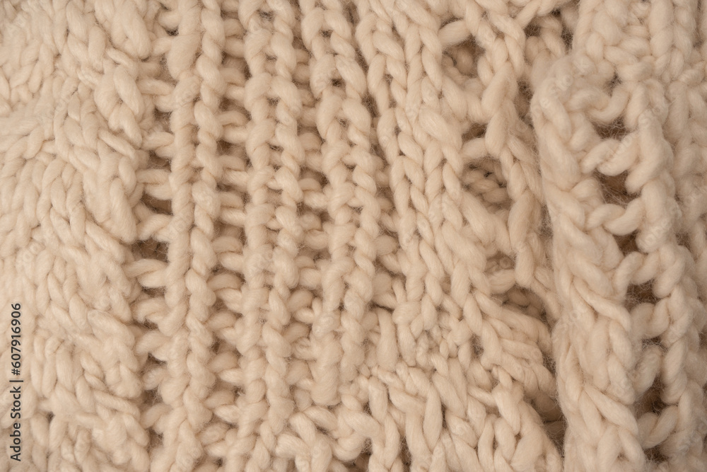 A fragment of beige knitted fabric, knitted from white sheep wool. A fragment of beige knitted fabric, knitted from white sheep wool.