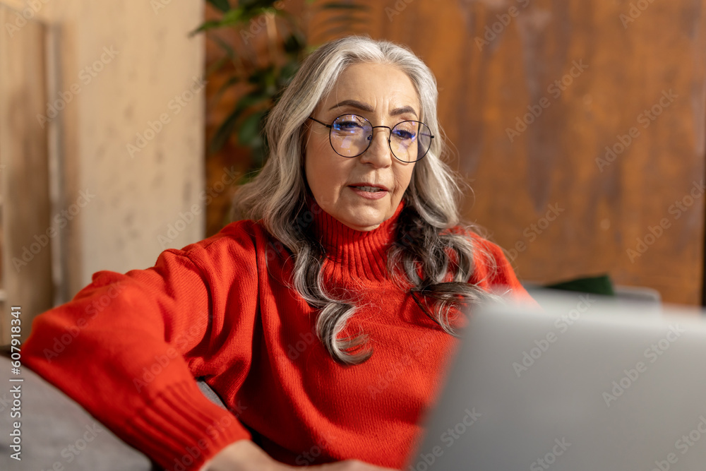 Woman in red shirt watching something on laptop Woman in red shirt watching something on laptop