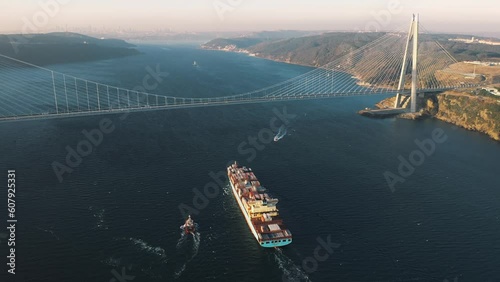 A large container ship heading towards the Istanbul. Aerial Bosphorus Sea. Cargo vessel sails under the Yavuz Sultan Selim Bridge in the early morning
