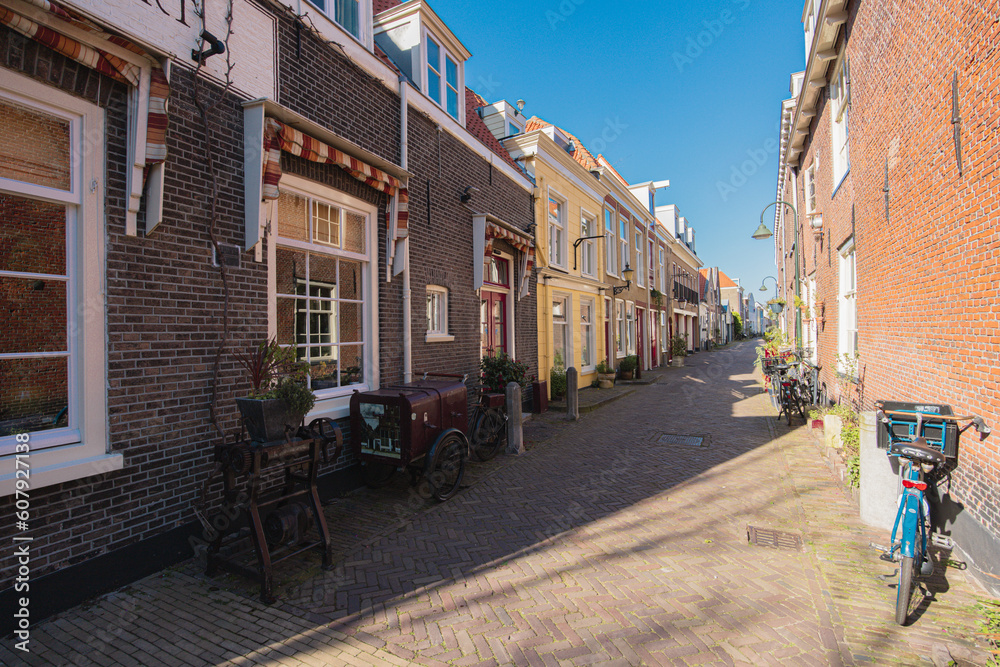A red brick house wall, with a bench and a bicycle in front of it, in Delft, Netherlands