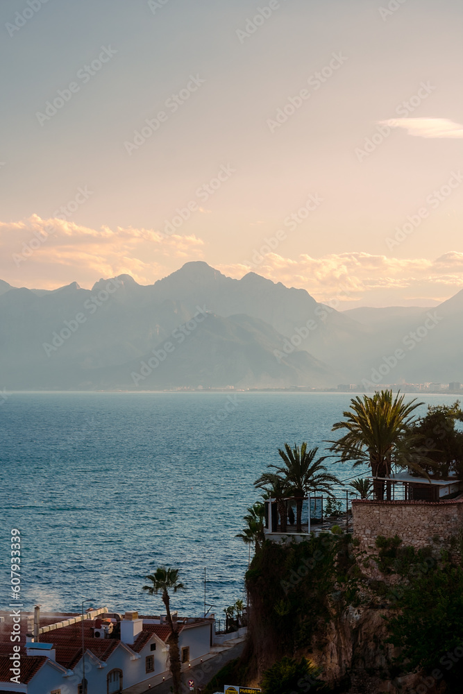 View of the mountains, sea and palm trees in the Turkish city of Antalya. Evening in Antalya. Evening in Antalya.