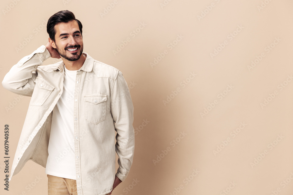 Portrait of a stylish man smile with teeth happiness opened his mouth in surprise on a beige background in a white t-shirt looks at the camera, fashionable clothing style, copy space, space for text Portrait of a stylish man smile with teeth happiness opened his mouth in surprise on a beige background in a white t-shirt looks at the camera, fashionable clothing style, copy space, space for text