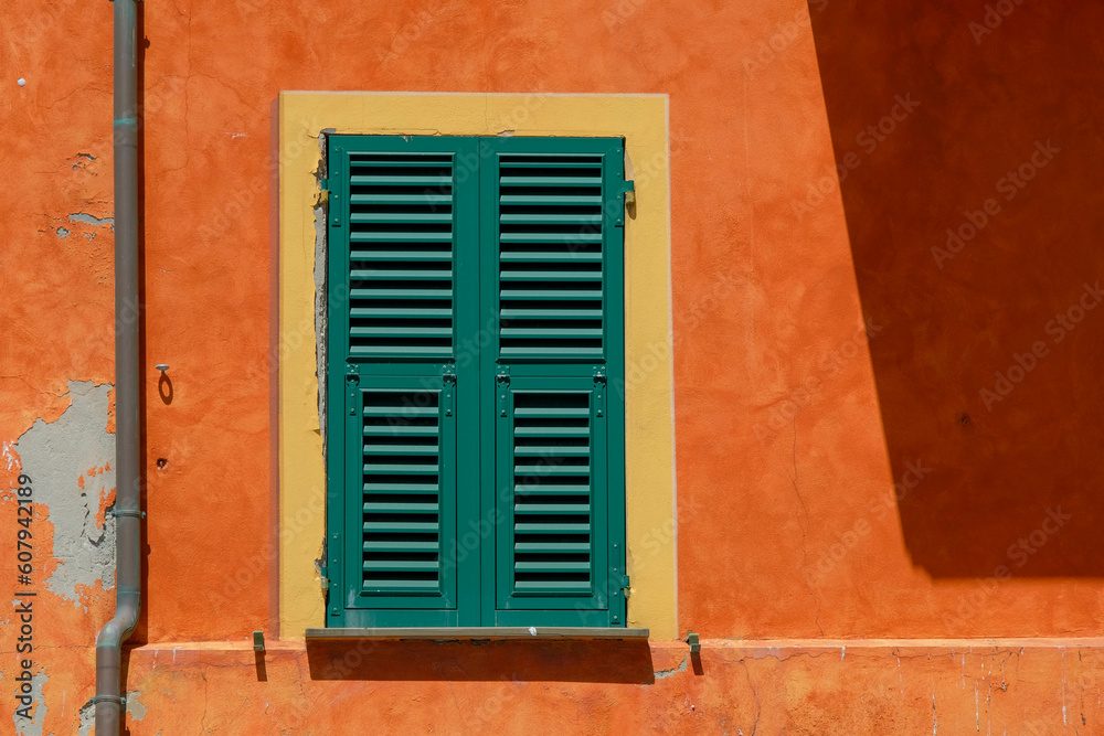 Sturdy green shutters and flaking orange wall in Camogli, Italy Sturdy green shutters and flaking orange wall in Camogli, Italy