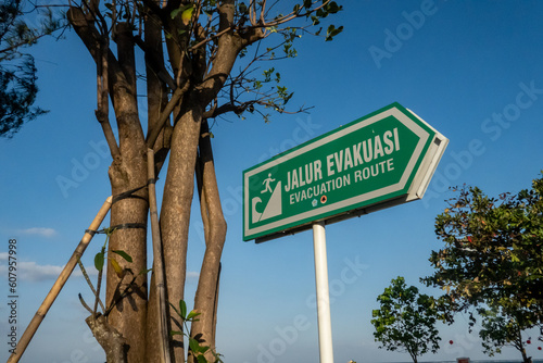 Sanur, Bali, Indonesia A green safety sign on the beach points to an evacuation route in case of a tsunami.