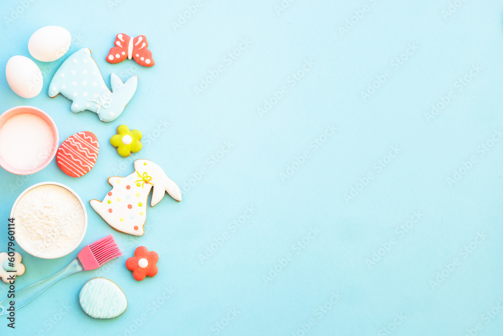 Easter baking background on blue. Flour, edds, sugar and gingerbread cookies. Top view with copy space. Easter baking background on blue. Flour, edds, sugar and gingerbread cookies. Top view with copy space.