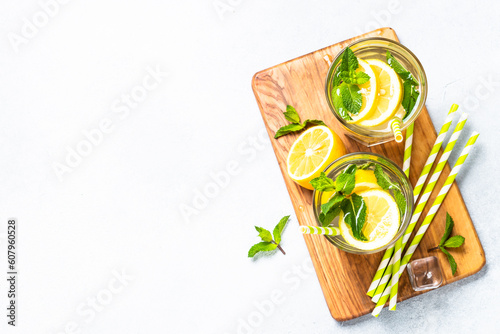 Lemonade in glass on white table. Cold summer drink top view with copy space.