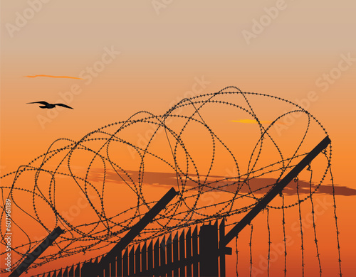 Vector illusration of metalic fence topped with barbed wire against sunset sky