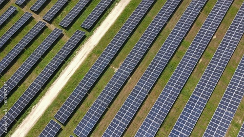 Aerial view of the rows of solar panels, large solar power plant. Production of a large amount of clean electricity from renewable sources. The concept of zero emissions and environmental protection
