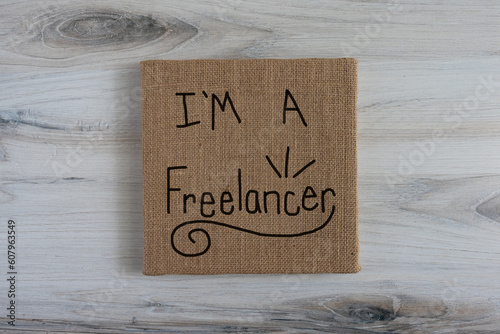 I'm a freelancer, hand written sign on brown neutral burlap canvas photo