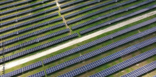 Aerial view of the rows of solar panels, large solar power plant. Production of a large amount of clean electricity from renewable sources. The concept of zero emissions and environmental protection