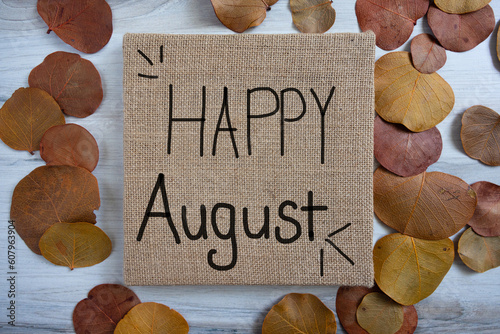 Happy August sign written on brown square burlap canvas autumn themed.