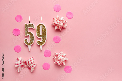 Number 59 on pastel pink background with festive decor. Happy birthday candles. The concept of celebrating a birthday, anniversary, important date, holiday. Copy space. Banner