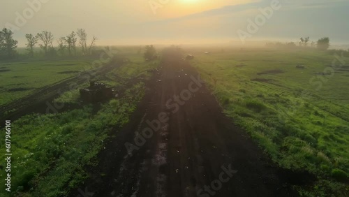 Flight over the road after hostilities. Ukrainian military vehicles, SUVs, and tanks were blown up and shot up all around. The field after the mortar shelling and artillery of the Russian invaders.