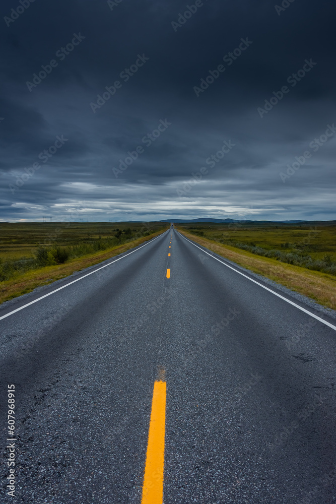 Epic cloudy landscape of an empty highway through the tundra of  Norway