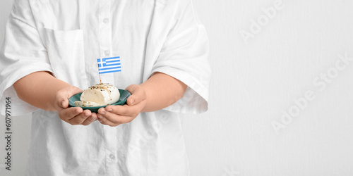 Fototapeta Naklejka Na Ścianę i Meble -  Person holding Greek cheese on light background