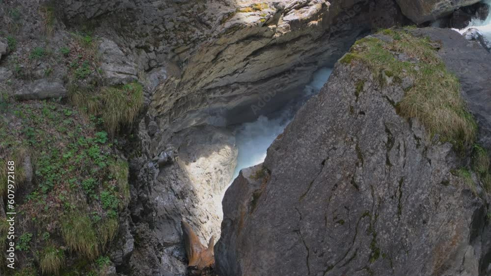 River between rocks of a narrow gorge. Stream of water is squeezed between the sides of the rocks. Linthschlucht, Linth Gorge, Linthal, Canton of Glarus, Switzerland River between rocks of a narrow gorge. Stream of water is squeezed between the sides of the rocks. Linthschlucht, Linth Gorge, Linthal, Canton of Glarus, Switzerland