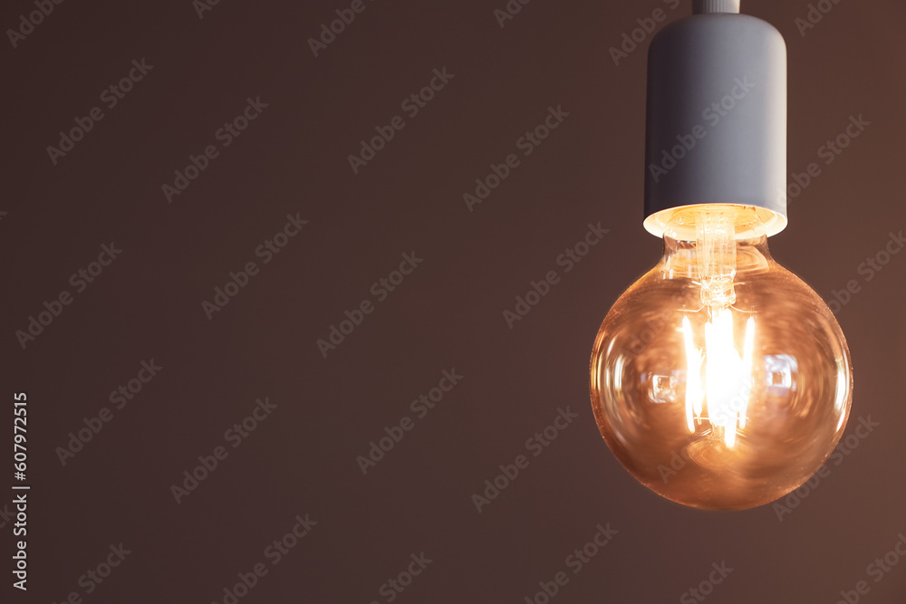 Glowing light bulb in dark room, closeup Glowing light bulb in dark room, closeup