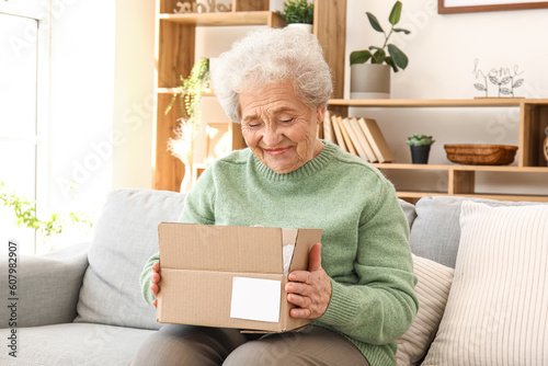 Senior woman opening parcel...