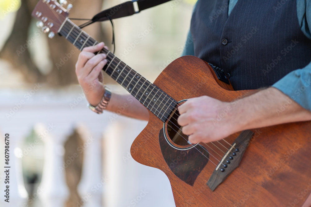 Professional guitarist plays guitar outdoors. Musician plays a classical guitar in the park.
