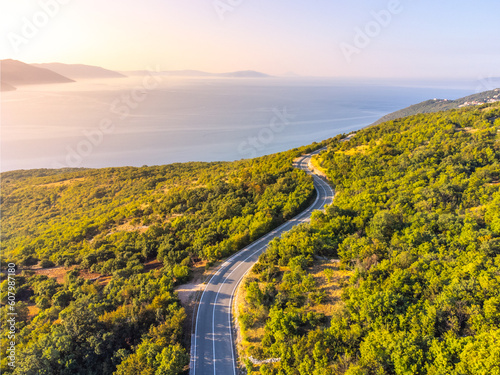 Winding coastal road, rocky cliffs and blue sea in sunny morning. Istria, Croatia