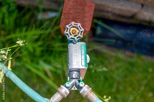 Εκτύπωση καμβά Garden water timer on a spigot with a splitter and hoses.