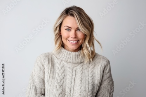 Portrait of a beautiful smiling woman in sweater on a white background