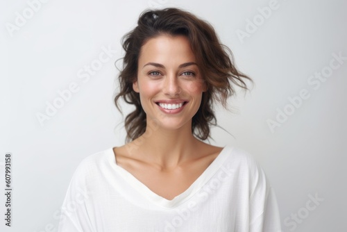 Portrait of beautiful young woman smiling and looking at camera over white background