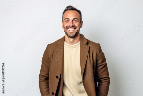 Portrait of a handsome young man smiling on a white background.