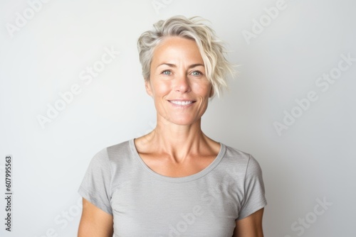 Portrait of beautiful middle aged woman smiling at camera against white background
