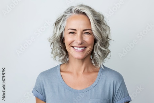Portrait of happy mature woman looking at camera over white background.