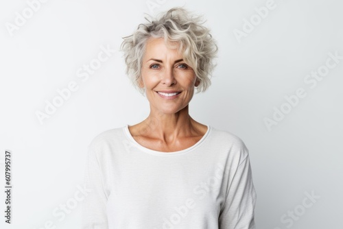 Portrait of beautiful mature woman smiling at camera over white background.