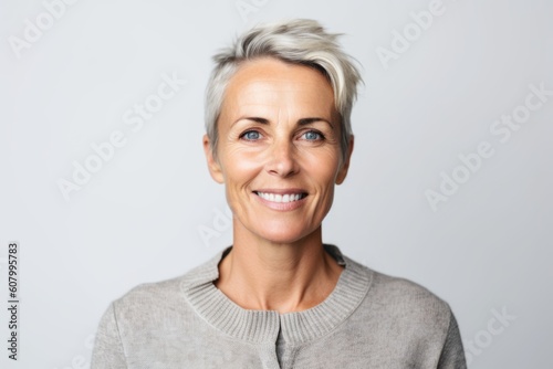 Portrait of happy mature woman smiling at camera over white background.