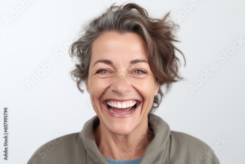 Close up portrait of a happy mature woman laughing against a white background
