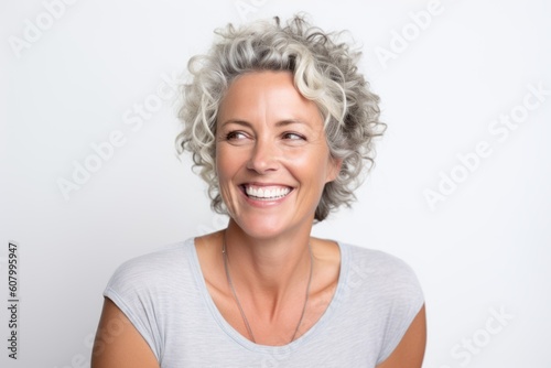 Portrait of a beautiful middle-aged woman with short grey hair smiling against white background