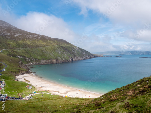 Keem bay and beach and Cliffs, Achill island, County Mayo, Ireland. Popular travel area with stunning nature scenery. Warm sunny day, cloudy sky. Irish tourism. Beautiful ocean view.