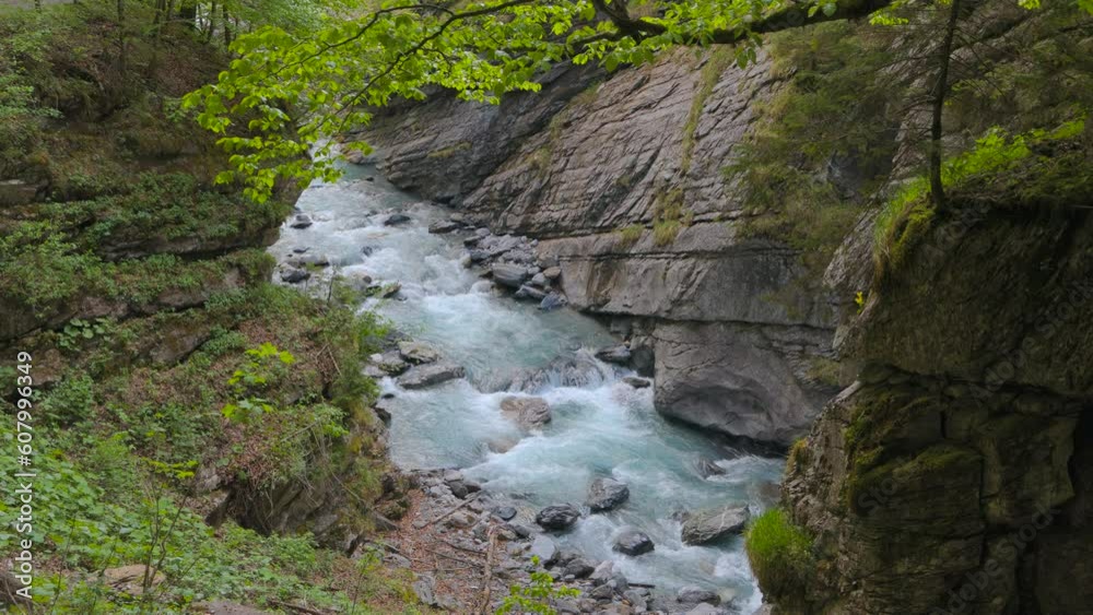 River between rocks of a narrow gorge. Stream of water is squeezed between the sides of the rocks. Linthschlucht, Linth Gorge, Linthal, Canton of Glarus, Switzerland River between rocks of a narrow gorge. Stream of water is squeezed between the sides of the rocks. Linthschlucht, Linth Gorge, Linthal, Canton of Glarus, Switzerland