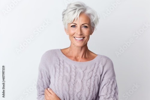 Portrait of smiling mature woman standing with arms crossed against white background
