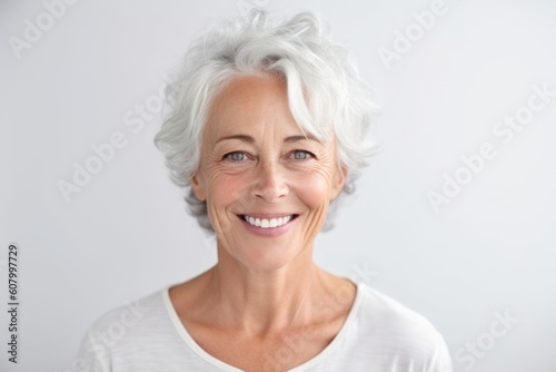 Close up portrait of smiling senior woman looking at camera over white background
