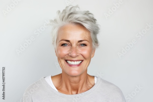 Portrait of a happy senior woman smiling at camera over grey background