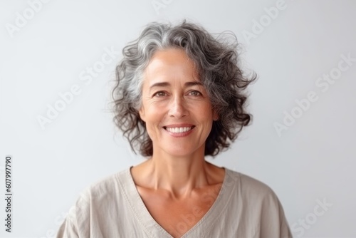 Portrait of smiling mature woman with grey hair looking at camera.