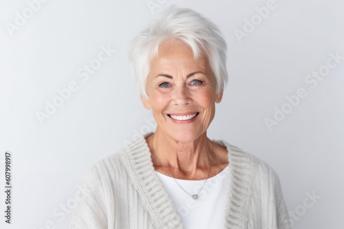 Group portrait photography of a grinning woman in her 60s that is wearing a chic cardigan against a white background . Generative AI