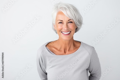 Lifestyle portrait photography of a grinning woman in her 60s on a white background