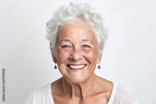 Close up portrait of a happy senior woman smiling on white background.