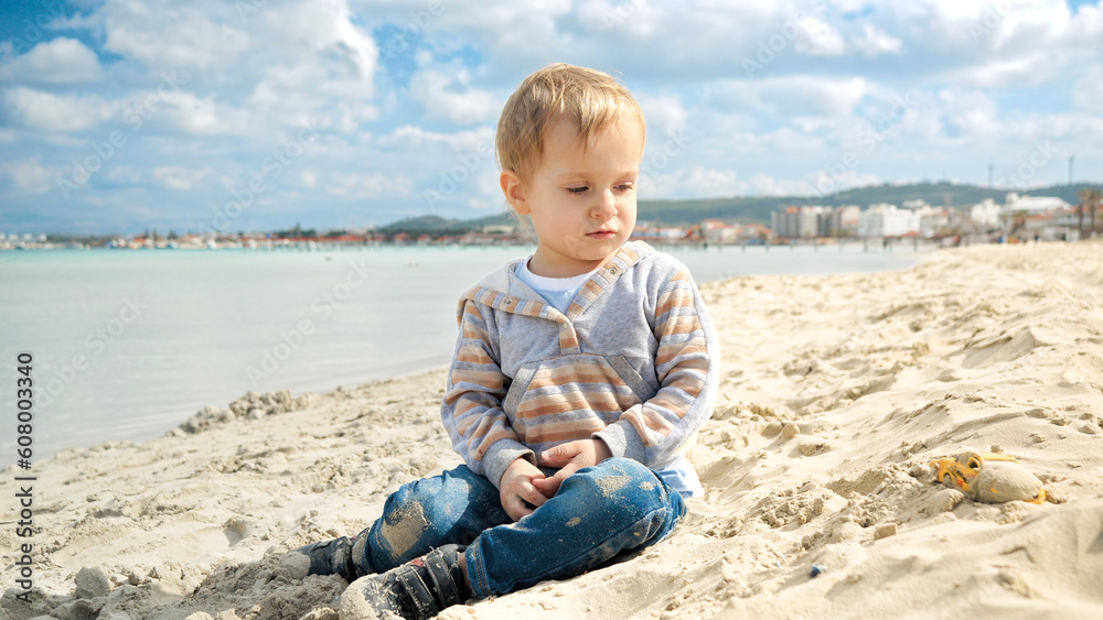 Little toddler's boy beach holiday, playing in the sand. Concept of tourism, travel, summer vacation Little toddler's boy beach holiday, playing in the sand. Concept of tourism, travel, summer vacation