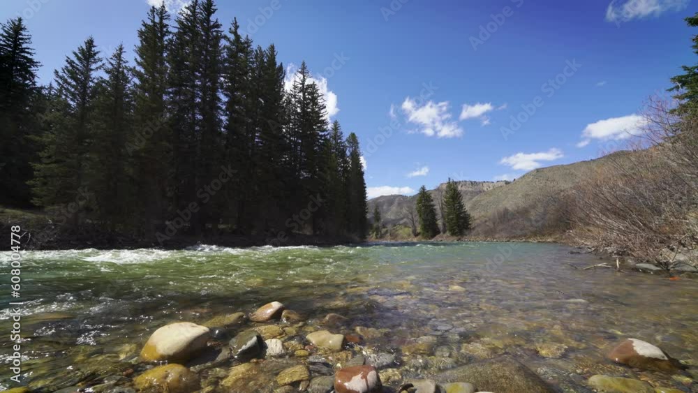 Low wide angle of Mountain river on sunny day flowing down stream