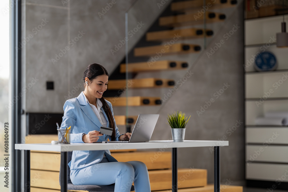Confident businesswoman working on laptop at her workplace at modern office Confident businesswoman working on laptop at her workplace at modern office