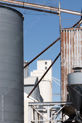 Detals of industrial grain elevator complex under clear blue sky
