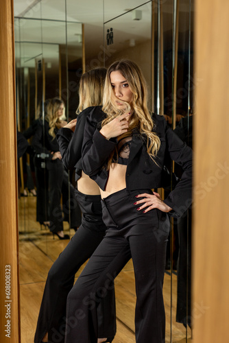 Beautiful young woman with bare stomach in black suit