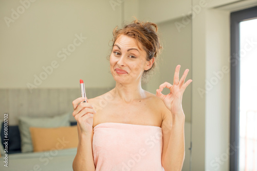 young pretty woman feeling happy  showing approval with okay gesture. lipstick concept